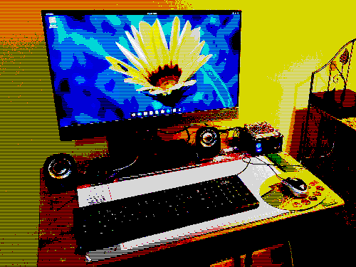 a mini desktop pc on a little desk for one. with a big screen with a flower on it, with a black mouse and keyboard, everything with a yellow backgroud